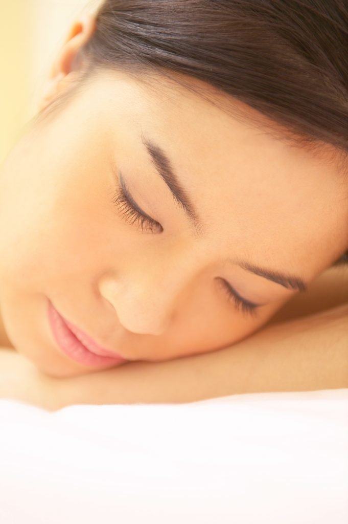 An up-close picture of an Asian closing her eyes