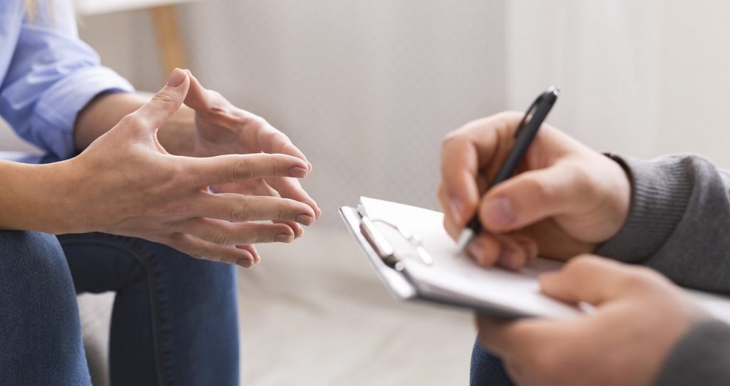 counseling | neurofeedback therapy for anxiety in englewood, co | neurofeedback colorado | neurofeedback englewood | neurofeedback and anxiety | neurofeedback therapy | 80127 | 80128 | 80124 Image of someone in therapy speaking with a therapist who writes on a clipboard. Overcome your anxiety symptoms in healthy way with the help of neurofeedback therapy for anxiety in Englewood, CO.