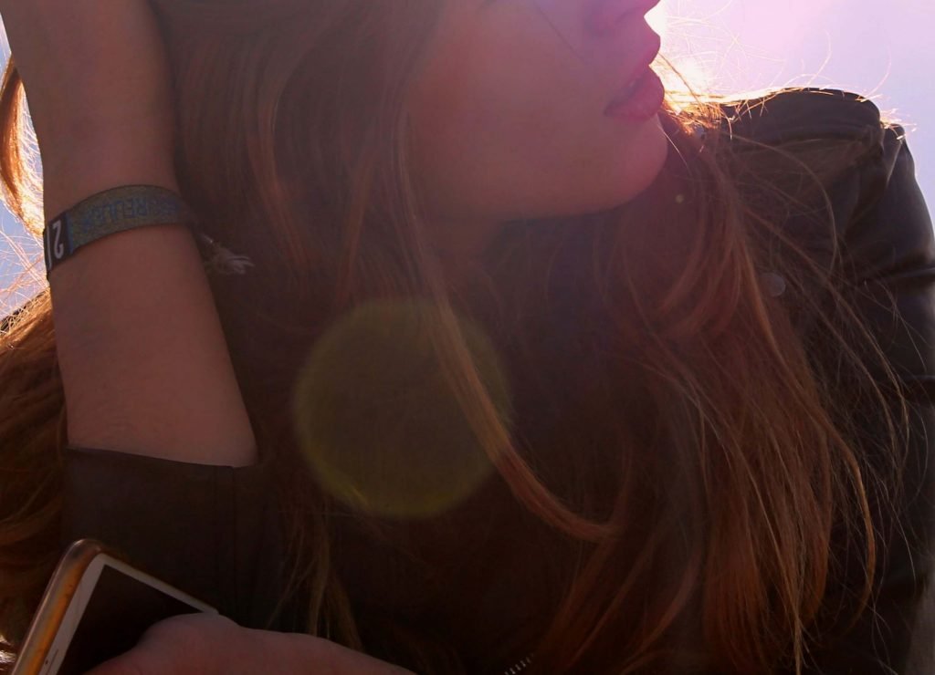 Image of a thoughtful woman holding her hand in her hair as the sun shines on her. Discover how EMDR therapy in Denver, CO can help you overcome trauma symptoms.