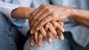 A close up of a couple holding hands. This could represent the love cultivated by working with a couples therapist in Englewood, CO. Search for couples therapy in Littleton, CO, and how relationship counseling in Englewood, CO can help. 
