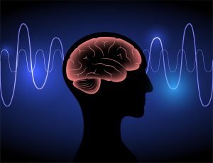 A digital illustration features a human head silhouette with a glowing red brain inside. Blue and purple waves surround the head, symbolizing brain activity. This could represent the process of neurofeedback therapy in Littleton, CO. Search for trauma therapy in Englewood, CO to get in contact with a neurofeedback therapist in Englewood, CO. 