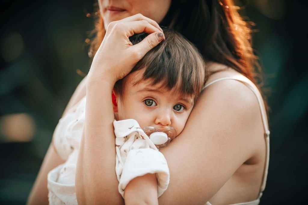 A woman holds her baby outside. Get help for postpartum depression and anxiety in Colorado today. Start working with a maternal mental health therapist in Greenwood Village, CO, to overcome postpartum depression and anxiety.
