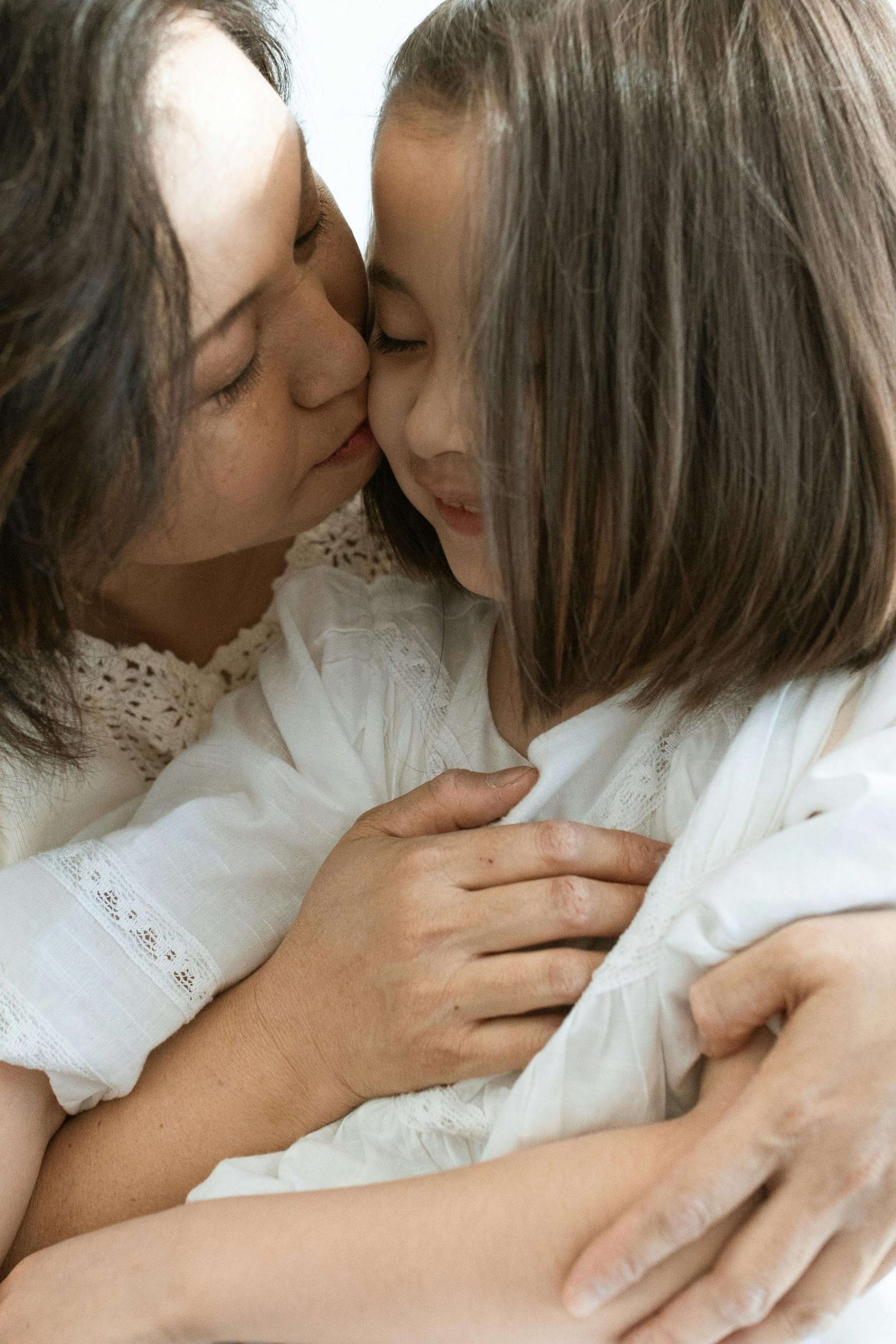 An asian woman hugs her daughter while smiling. Stay close to your little one in every stage of their life with help from maternal mental health counseling in Colorado. Contact a postpartum depression therapist in Greenwood Village to begin a journey toward inner peace. 