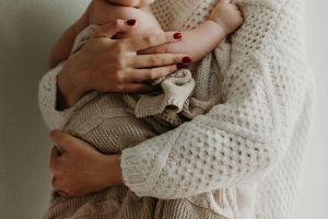 Woman holds baby | birth trauma therapist in englewood, co | online treatment for depression | postpartum depression and anxiety | Englewood, CO 80112 | 80128 | Denver, CO 80125 | 80110 A woman holds her baby wrapped in a blanket. Get in-person or online treatment for depression in Colorado. An experienced postpartum depression therapist in Englewood, CO, can help you bond with your baby and transition into motherhood.