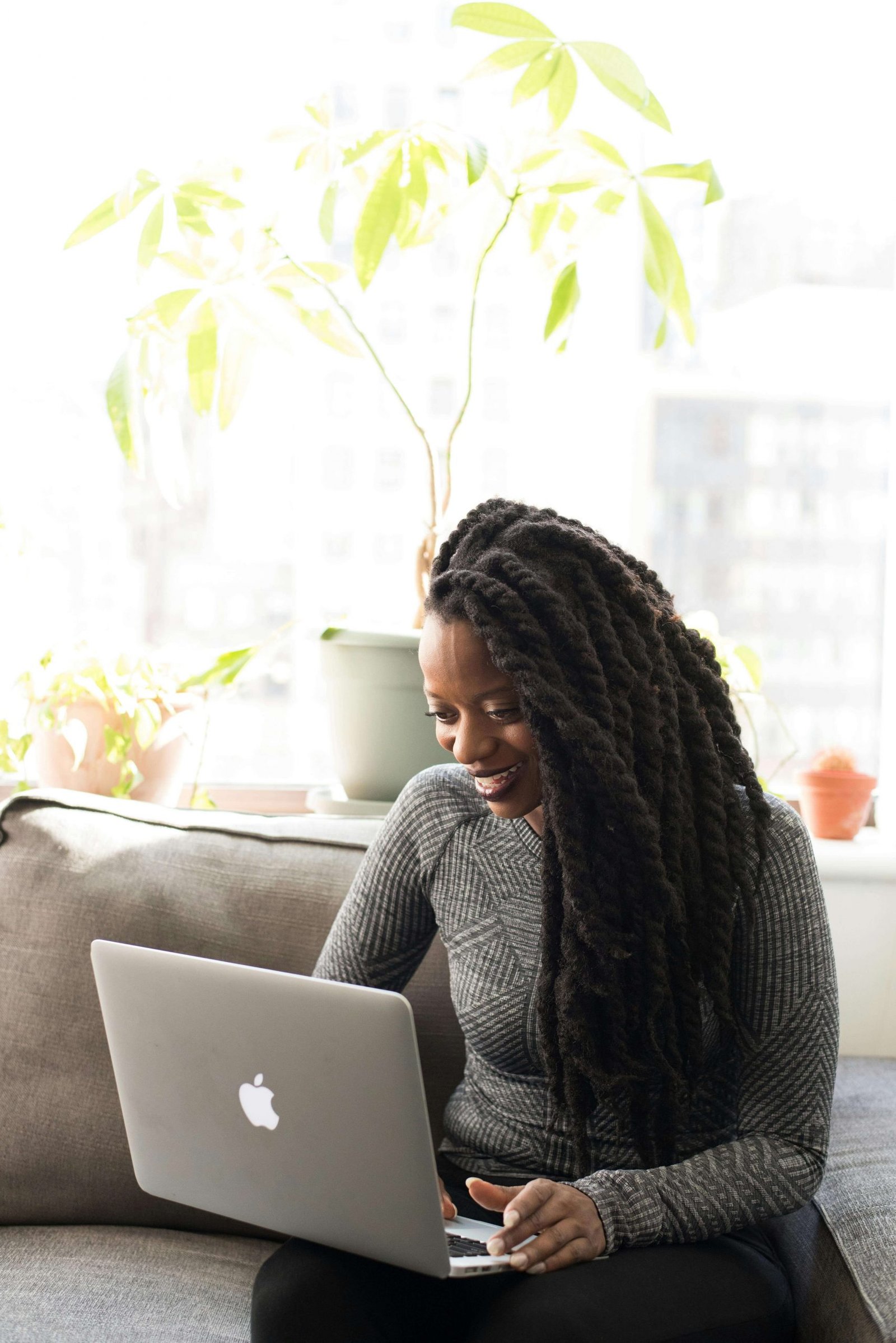Photo of a woman smiling at a laptop. Connect with an online therapist in Colorado for convenient telehealth. Explore the benefits of CBT, DBT, and EMDR online in Denver, CO, from the comfort of your own home. 