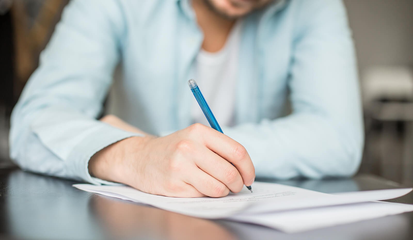 Close-up of an adult filling out intake forms before autism testing in Littleton, CO. Paperwork helps guide accurate autism testing in Englewood, CO and supports personalized autism treatment for adults in Colorado. 