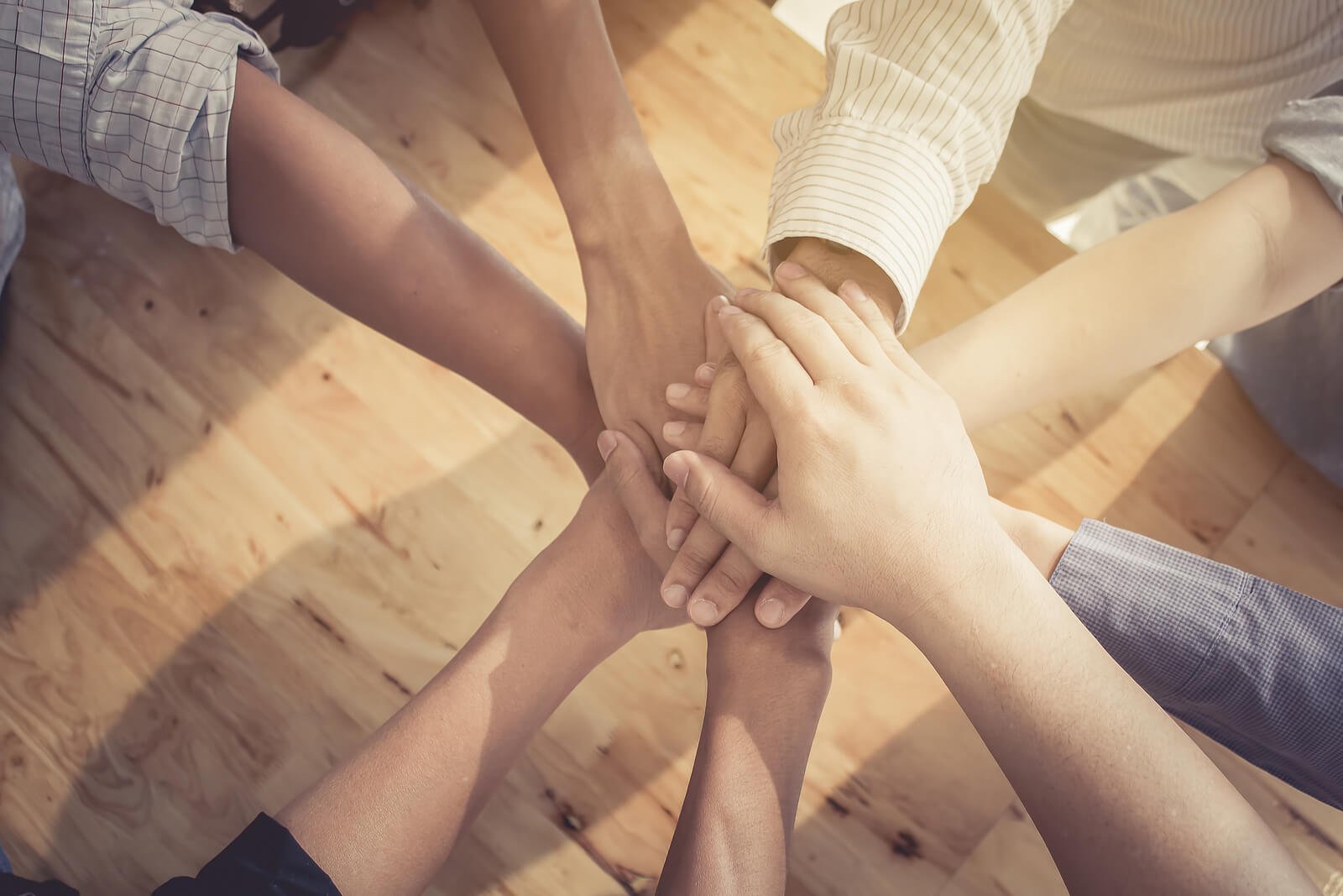 Hands stacked together to symbolize a strong support system for someone navigating an adult autism diagnosis denver. Community and family support can complement care from an autism therapist in greenwood village, co and follow-up resources after autism testing in littleton, co. 