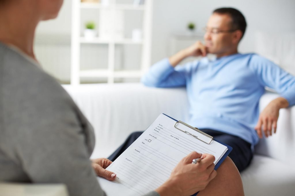 A therapist takes notes on a clipboard while a man reclines thoughtfully on a couch in a clean, calm therapy office. This kind of supportive, non-judgmental space is at the heart of autism treatment for adults in Colorado — a place to process a diagnosis, explore identity, and build a life that genuinely works for you. An autism therapist in Greenwood Village, CO can provide this consistent, professional guidance whether you are newly diagnosed or have been living with a diagnosis for years.